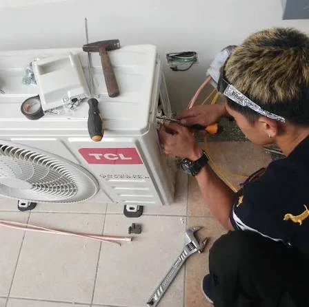 Technician servicing an outdoor air conditioning unit